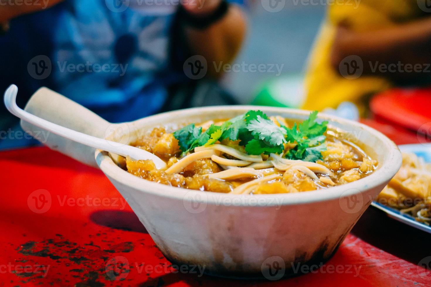 Braised fish maw in red gravy in white ceramic bowl served in restaurant at China town in Thailand. Selective Focusing. photo