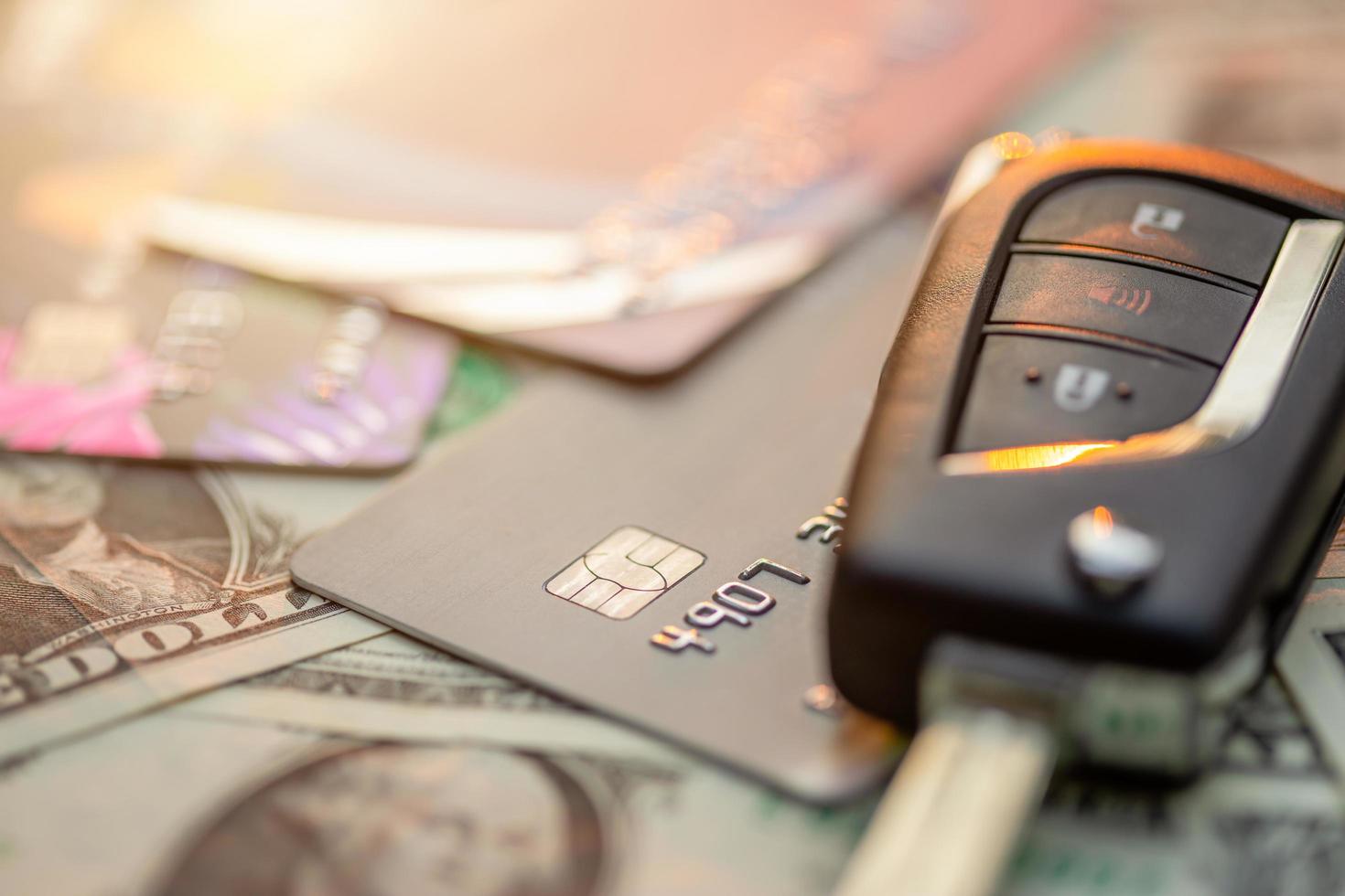 New car keys, credit card and US dollar banknote on wooden table. Car purchase or car rental concept photo