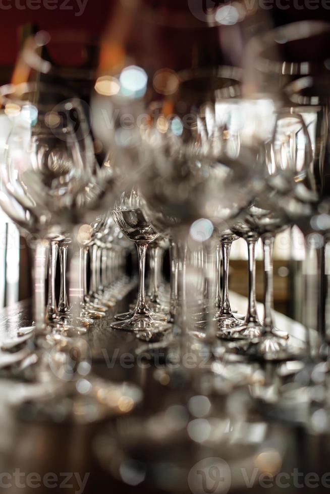 empty wine glasses. Beautiful new glasses for wine from glass stand in even rows on a wooden table in a restaurant. selective focus photo