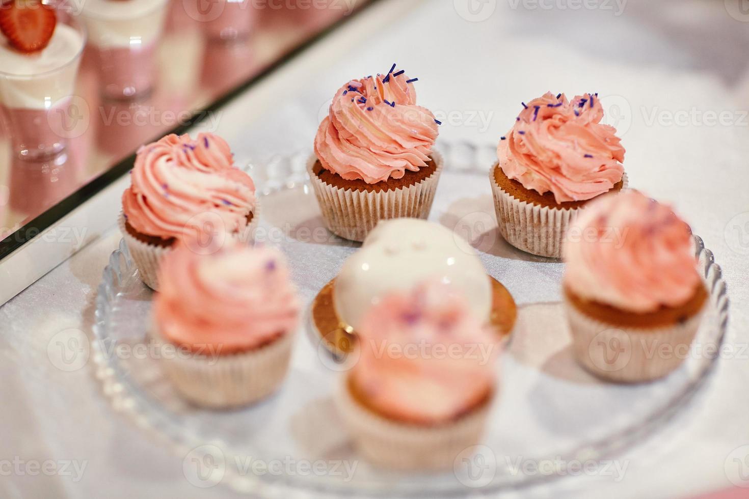 Set of different delicious tasty muffins on festive background. Different dessert tartlets with decorated cream. Selective focus. Candy bar concept photo