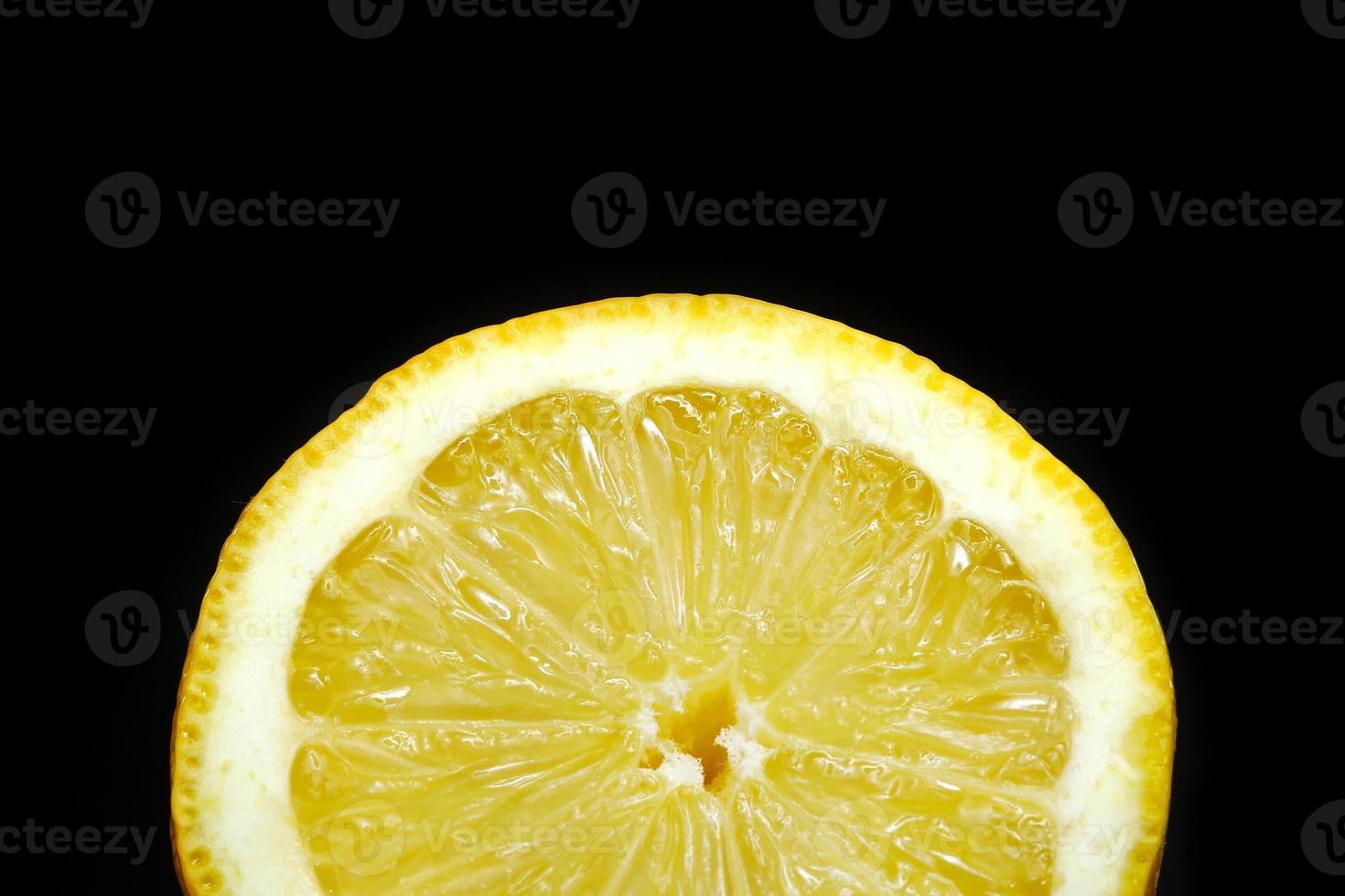 slice of yellow ripe lemon isolated on a black background. selective focus photo