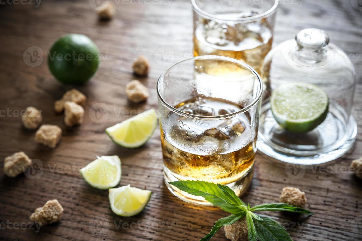 Glass of rum on the wooden background photo