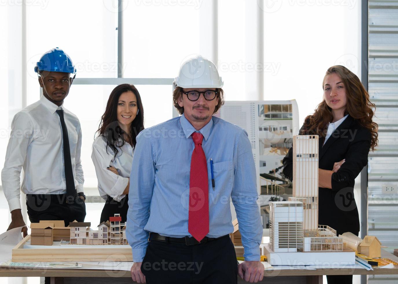 equipo de ingenieros y arquitectos de mediana edad parados en el cargo y mirando a la cámara foto