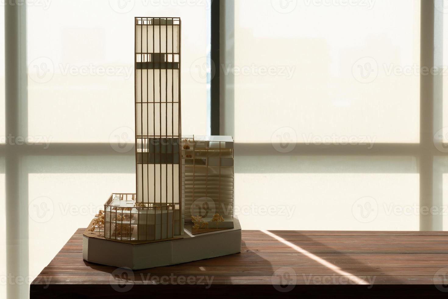 High Rise Building Model Made of Wood and Paper Placing on Table Near Window photo