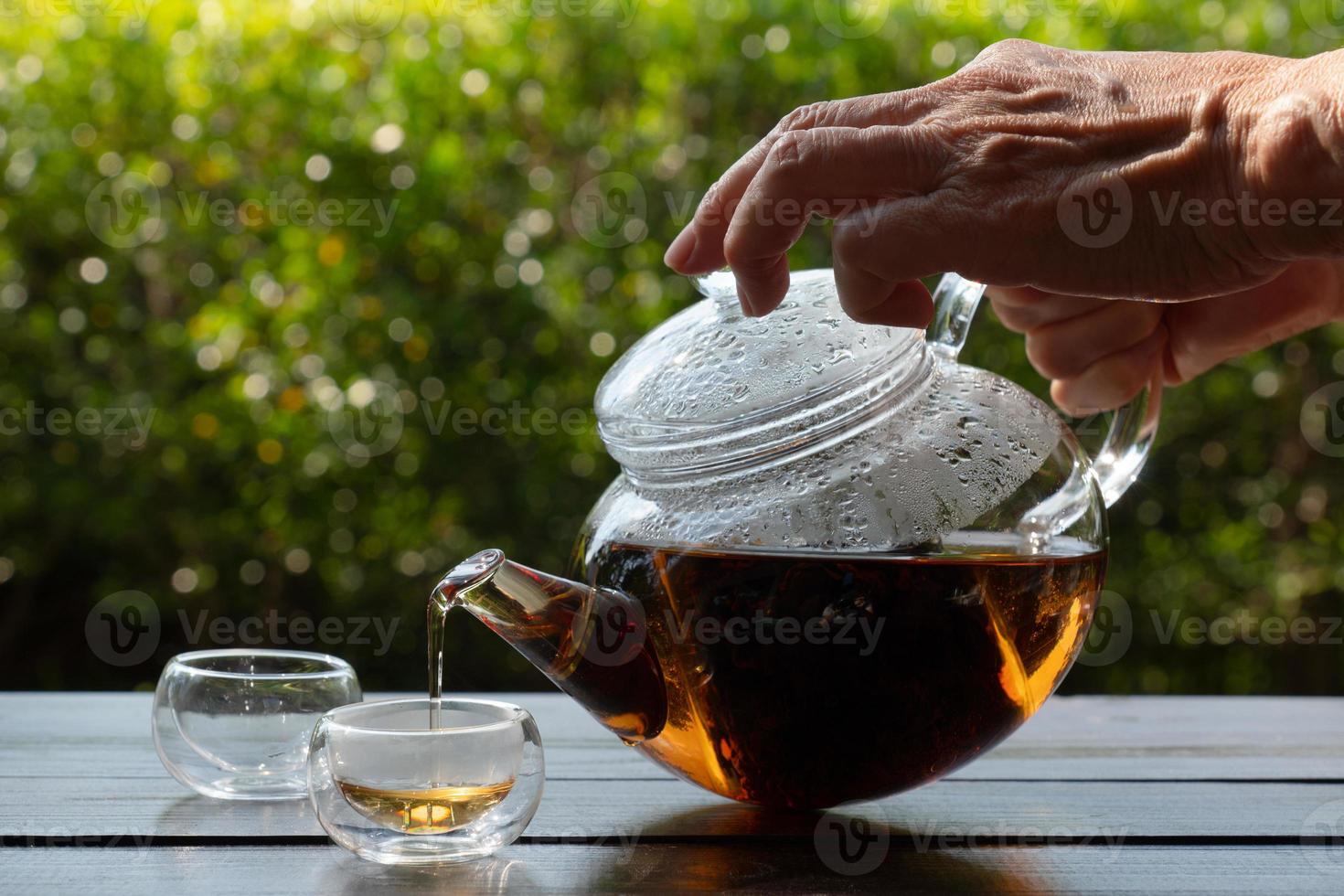 el té caliente se vertió en un vaso servido en la mesa del café foto