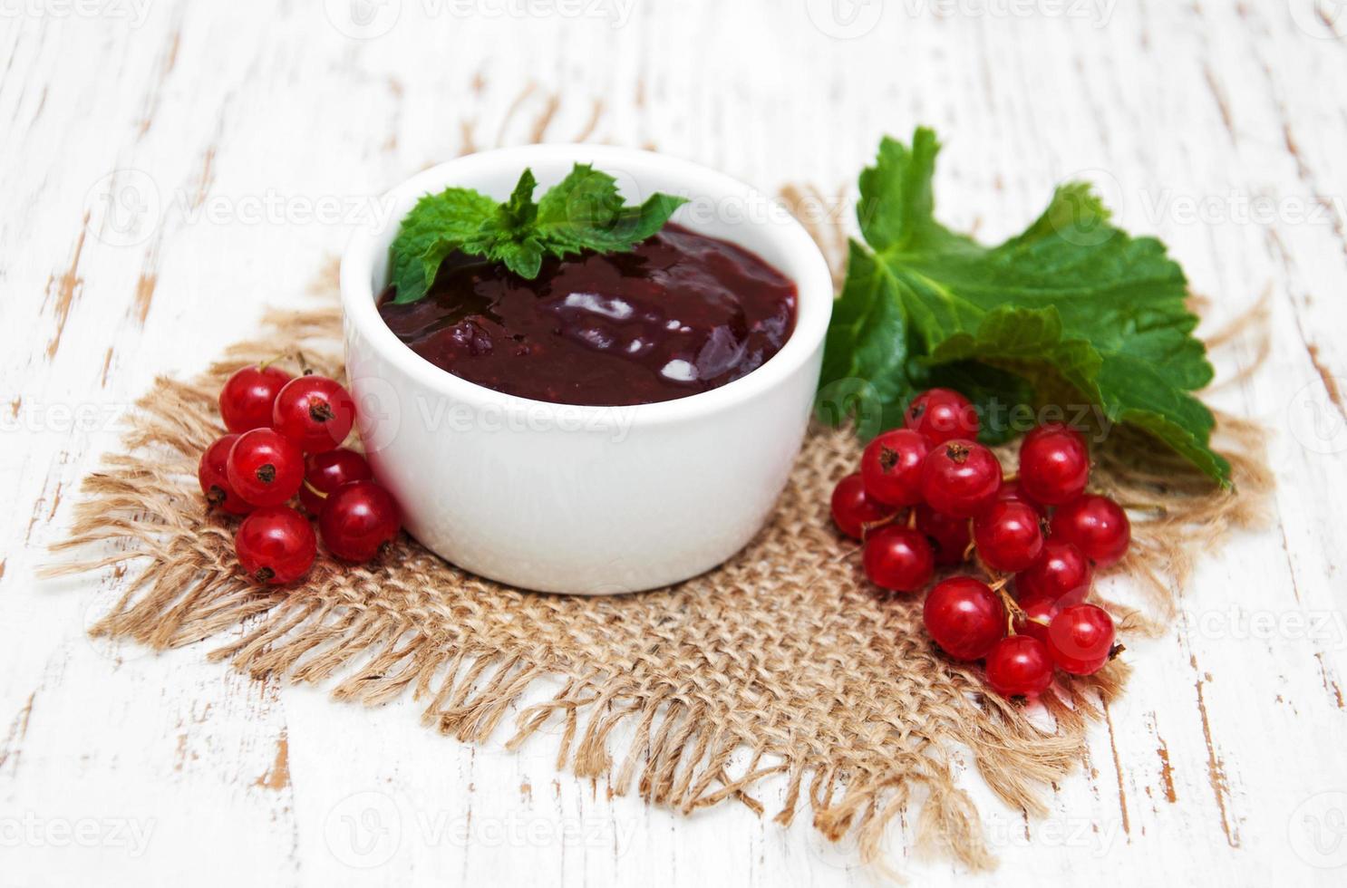 Redcurrants jam on table photo