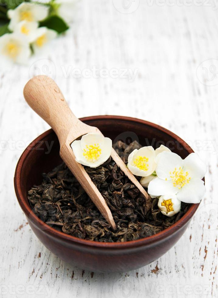 Dry green tea with jasmine flowers photo