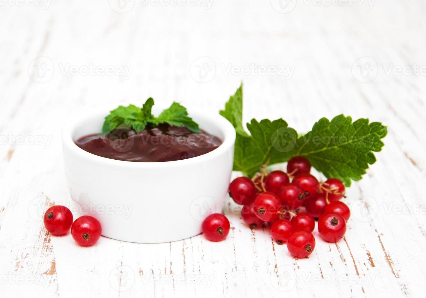 Redcurrants jam on table photo