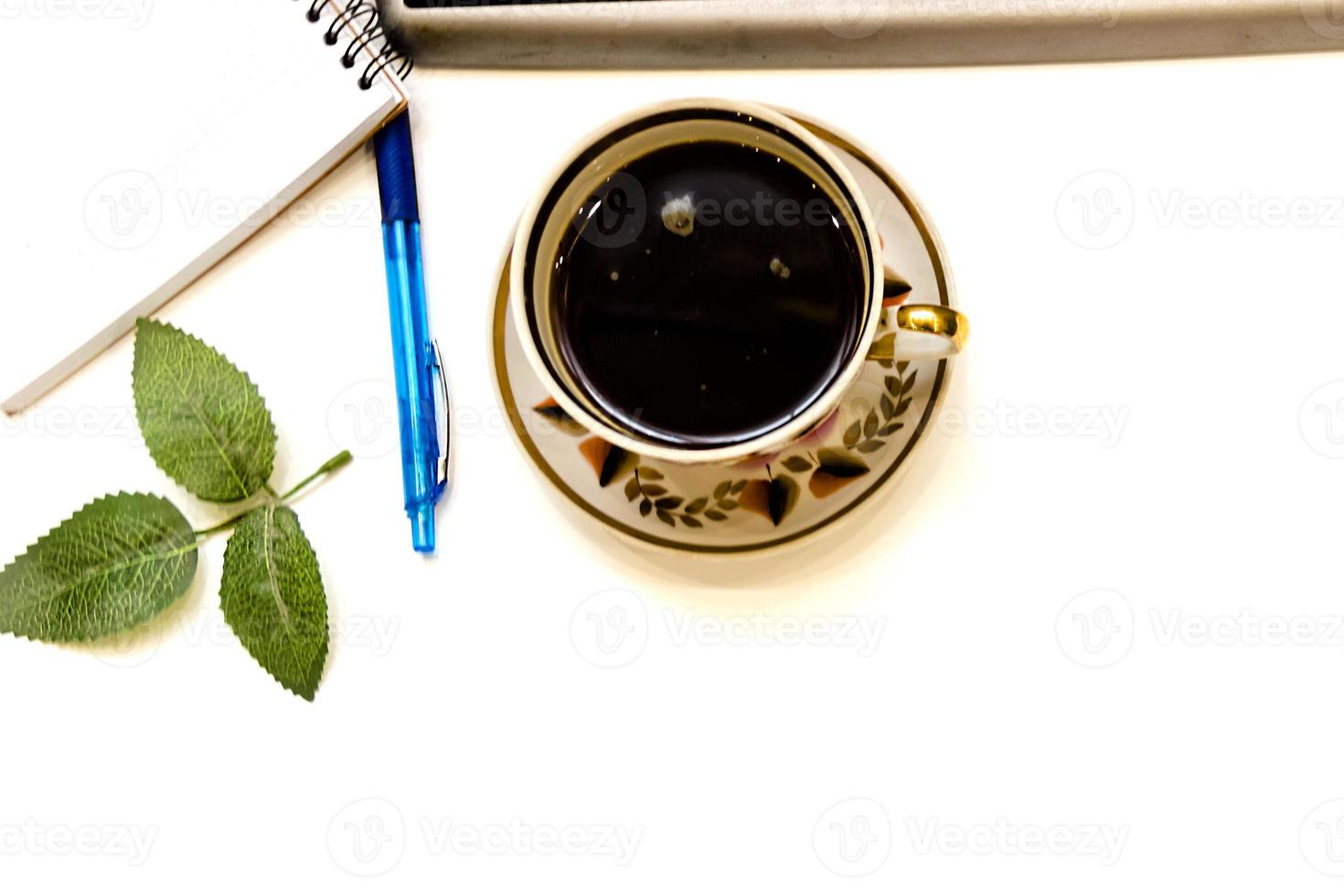 Cup of coffe and open notebook on white background photo