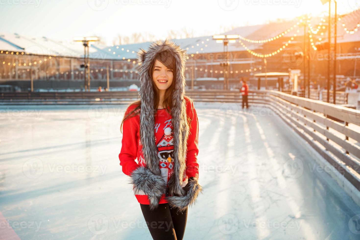 young happy woman in hat skating on ice on the street photo