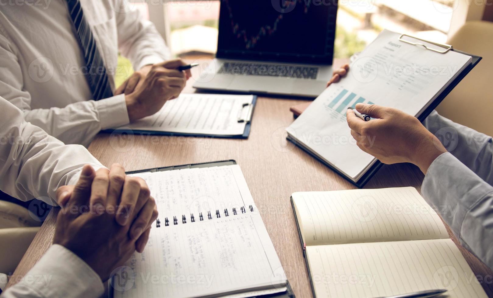 Group of usiness partnership coworkers working to chart company financial statements report and profits work progress and planning in office room. photo