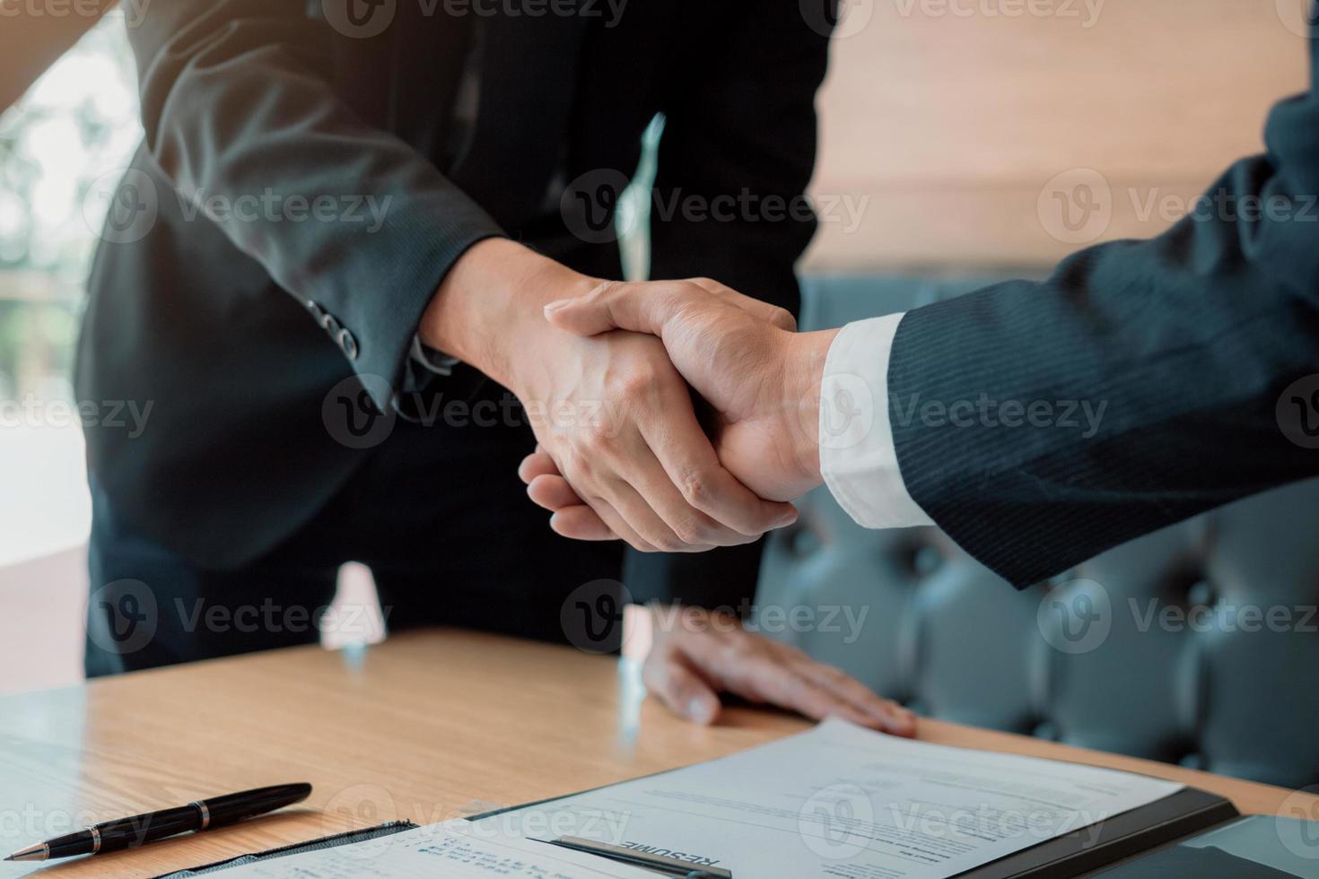 el gerente de los jefes de departamento se dan la mano y aceptan a un nuevo empleado en la sala de oficinas. foto