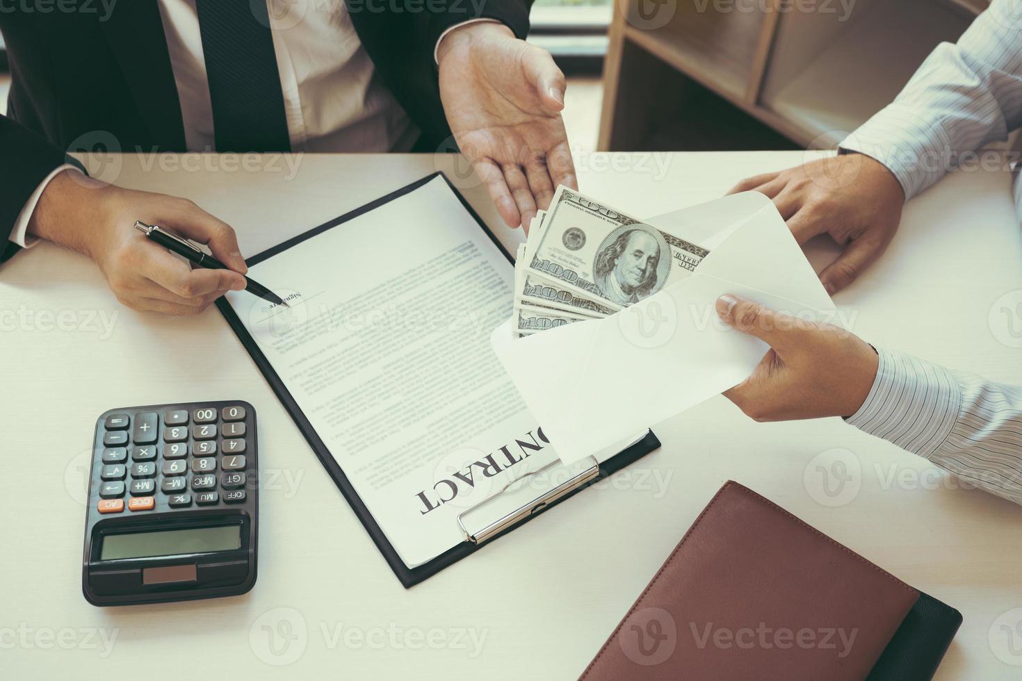 Partner has made a fraud in the contract of sale and being handed a cash and pen to the businessman signing the contract corruption bribery concept. photo