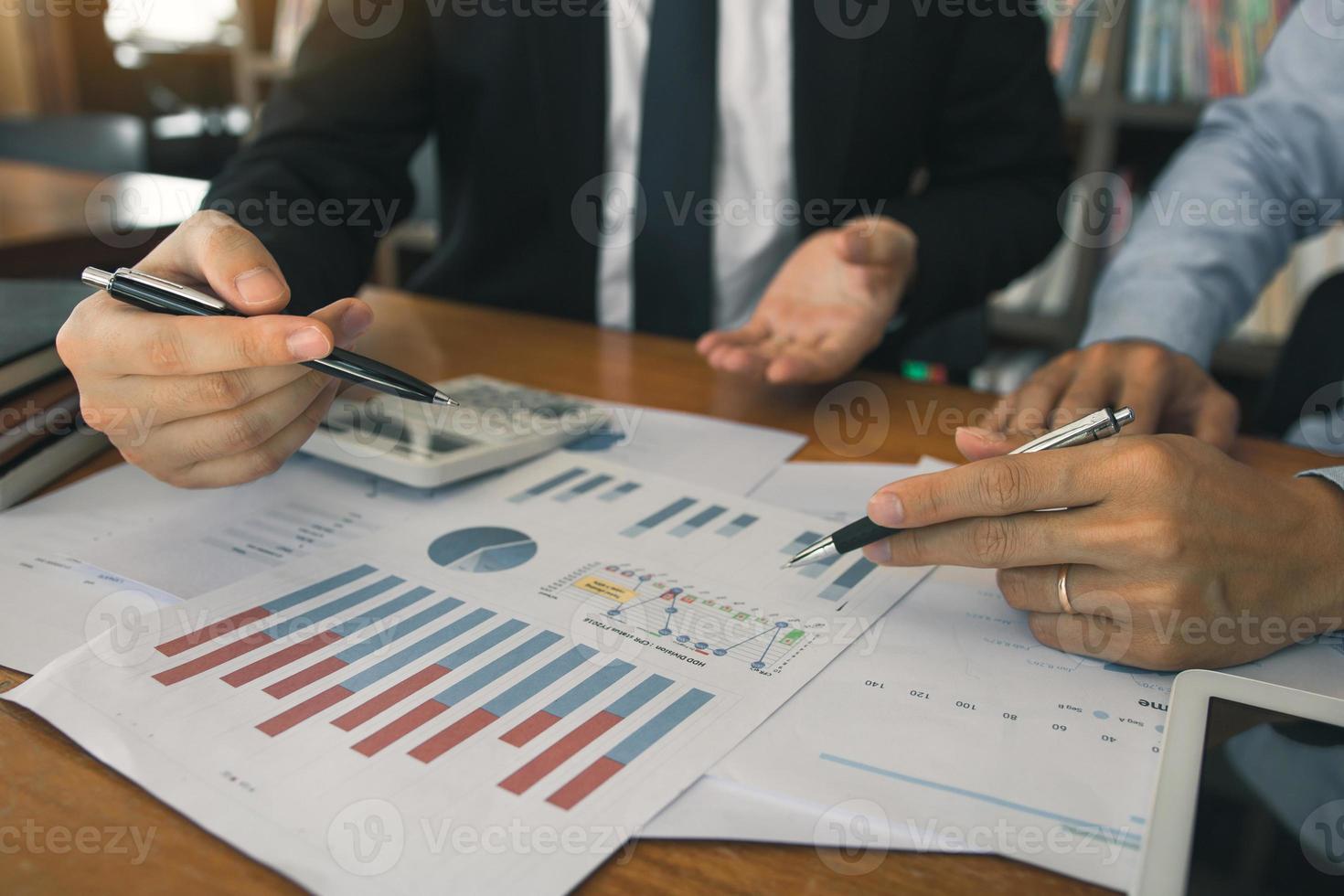 Two businessmen discussion analysis sharing calculations about the company budget and financial planning together on desk at the office room. photo