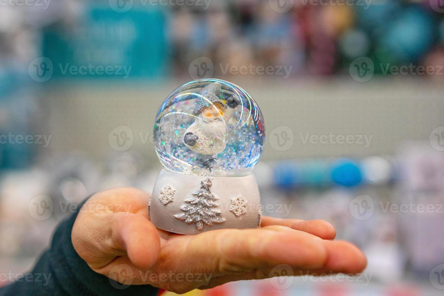 close up of a holding a snow globe in hand photo