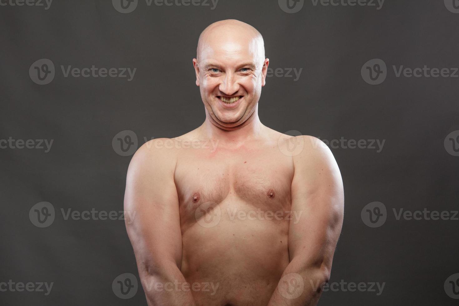 A man with a naked torso shows muscles in the background photo