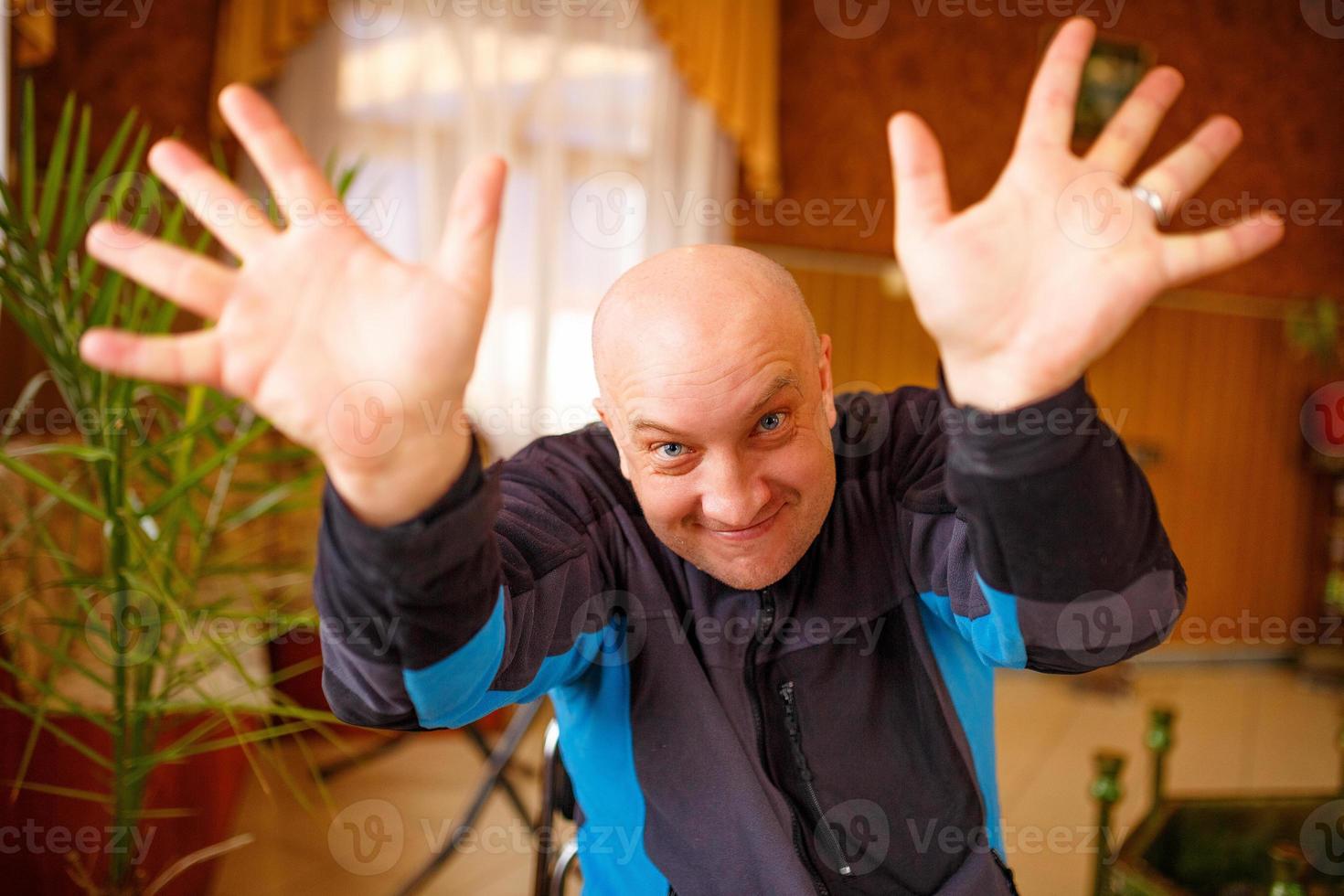 The funny bald man held up his hands palms out photo