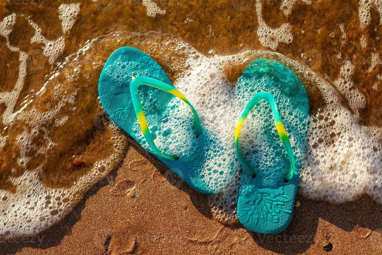 sandalias azules en la playa, el concepto de descanso en el mar foto