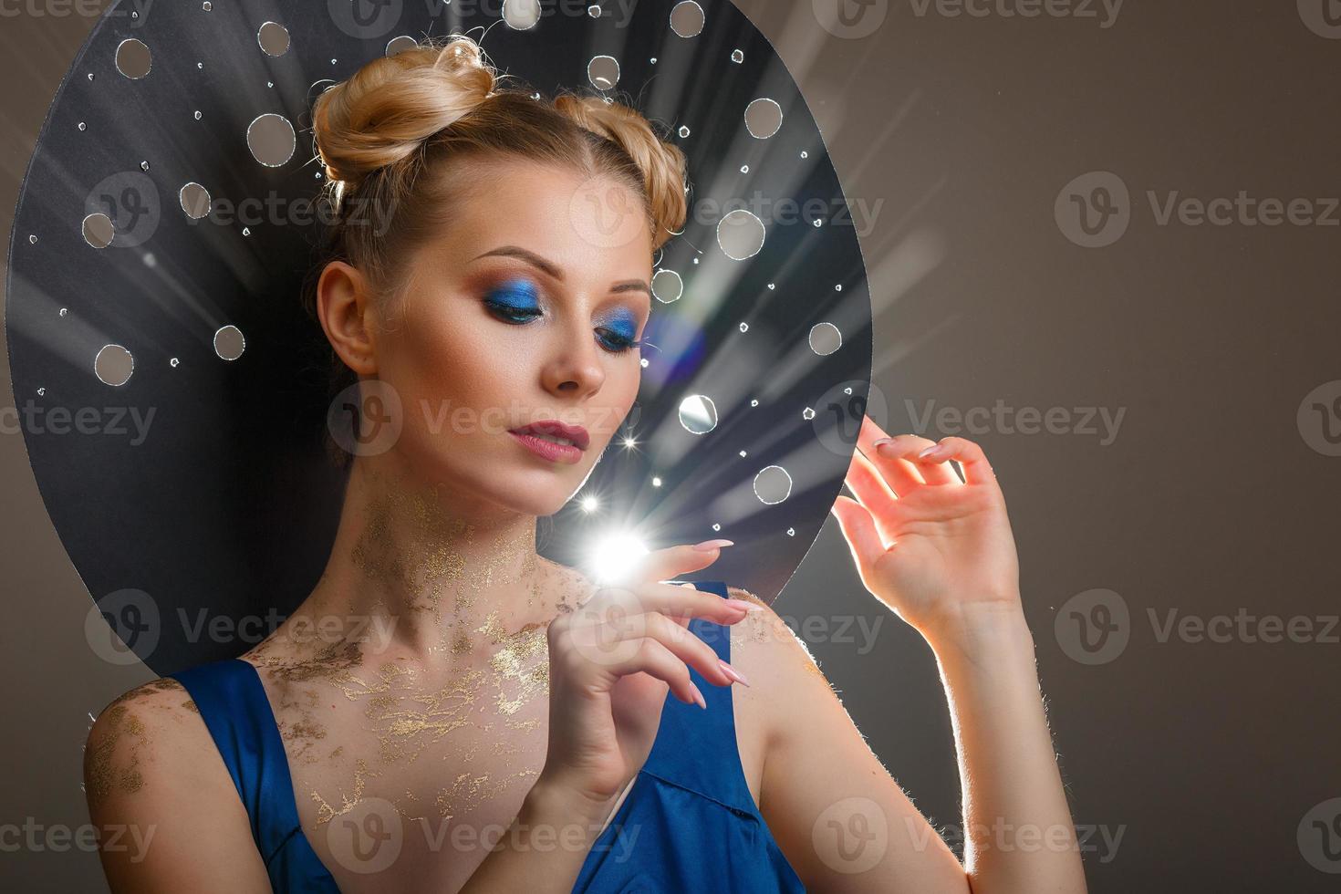 portrait of a beautiful woman with a make-up, original hat rays of light photo