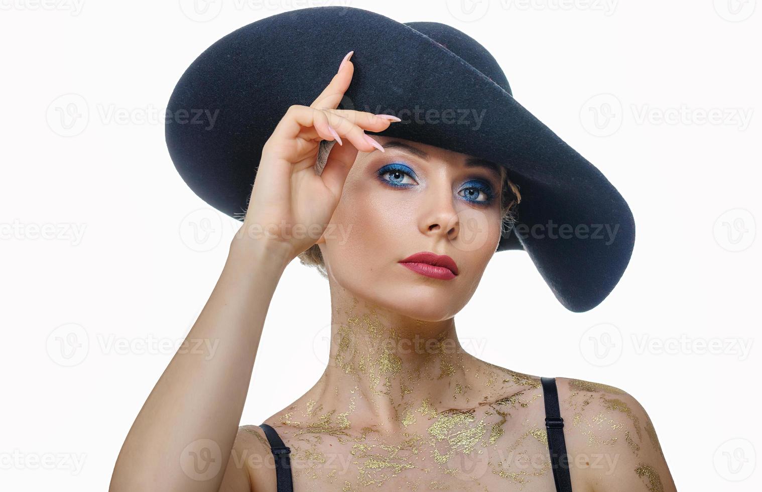 retrato de mujer hermosa con maquillaje en sombrero negro sobre fondo blanco, aislado foto