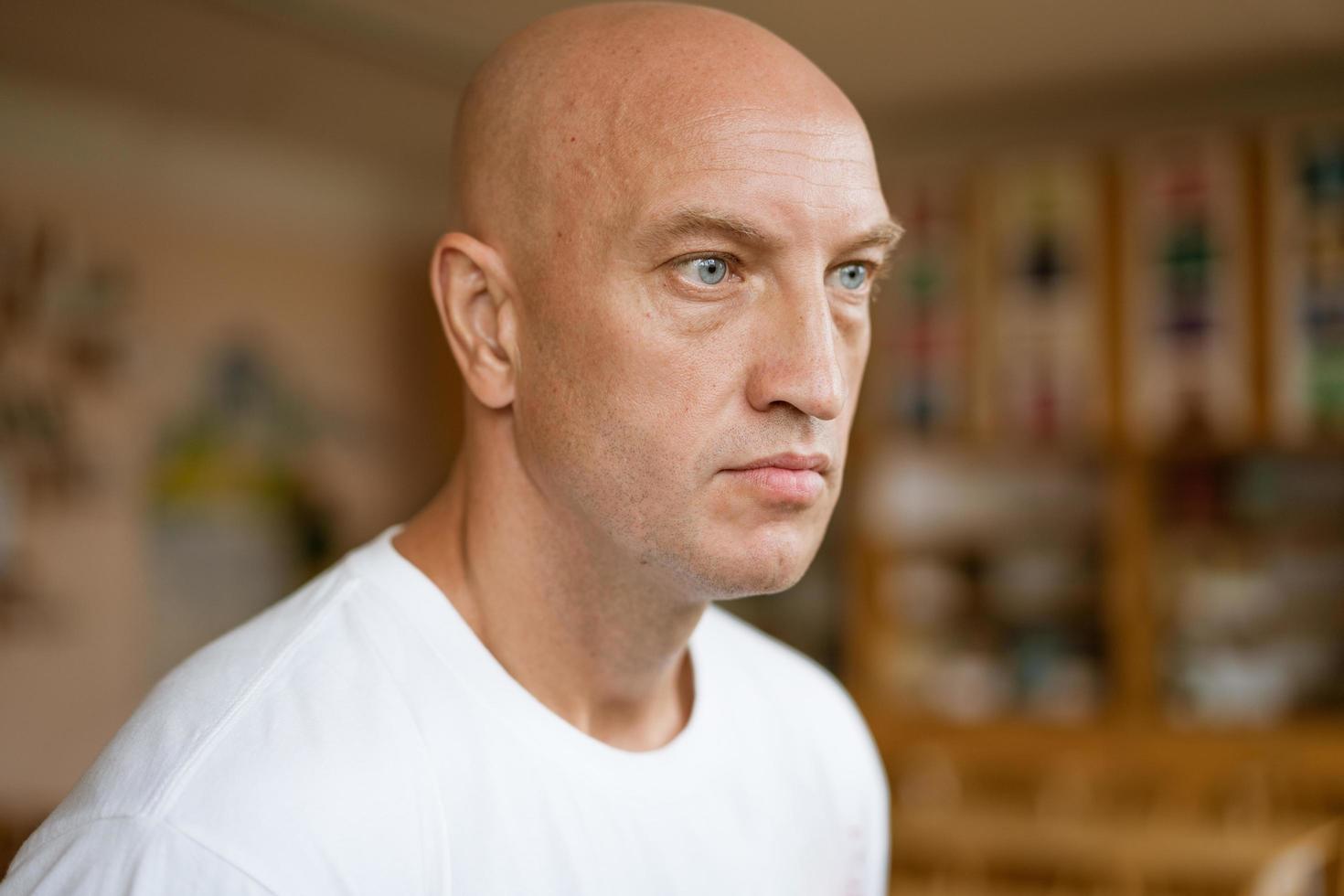 The man looks into the distance against the background of the room. photo