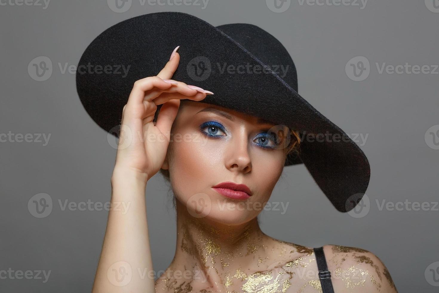 portrait of beautiful woman in with make-up in black hat on white background, isolated photo