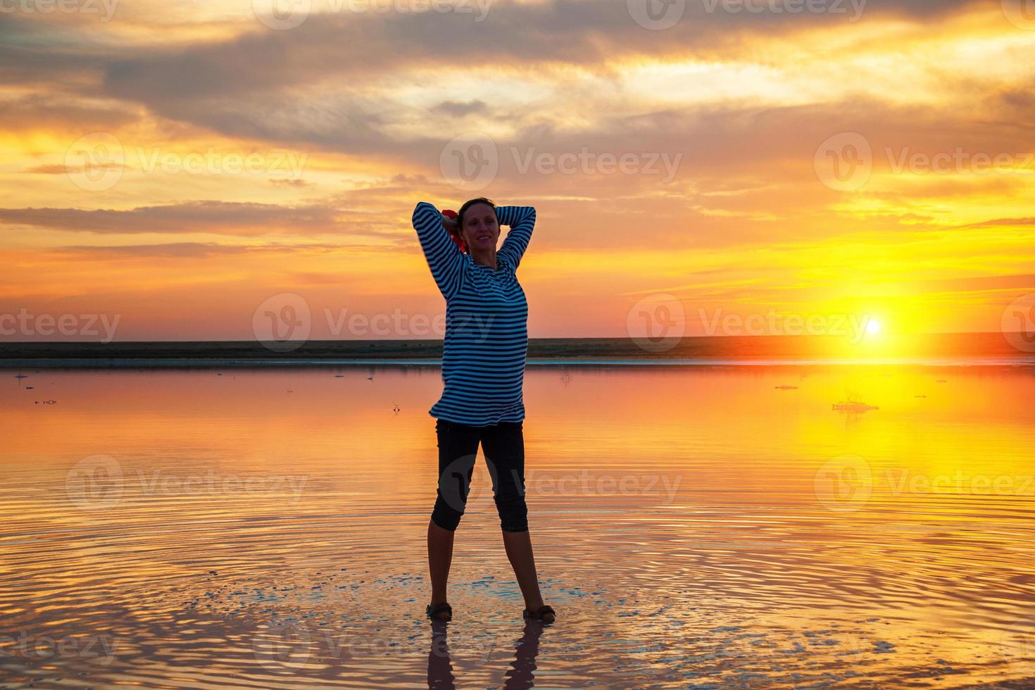 silhouette of a woman on the water at sunset, beautiful sunset sky with clouds, tourism concept photo