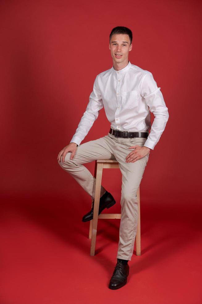 hombre de negocios atractivo y sonriente con camisa blanca y pantalones claros muestra foto