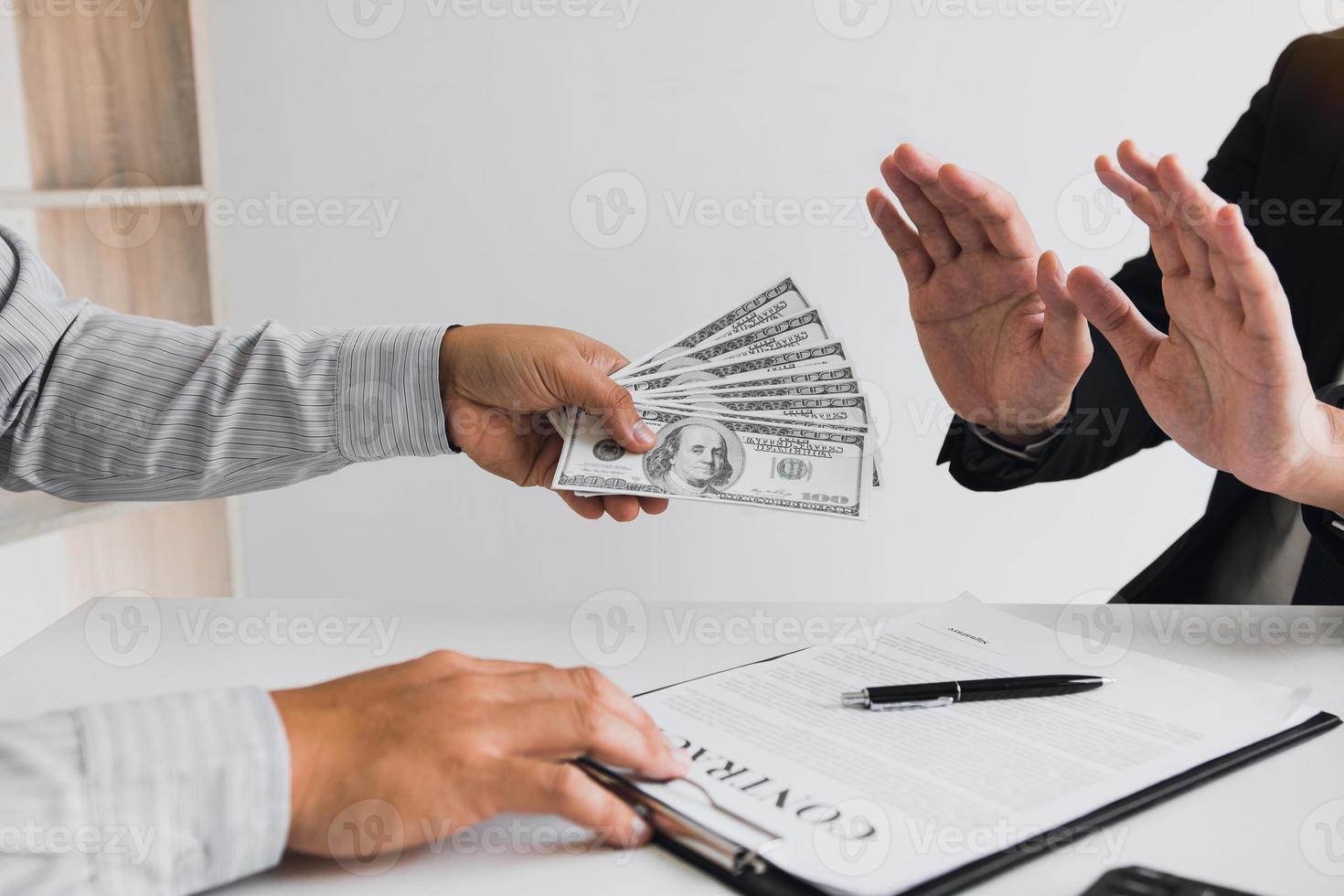 Business person refusing bribe given money by partner with anti bribery corruption concept. photo