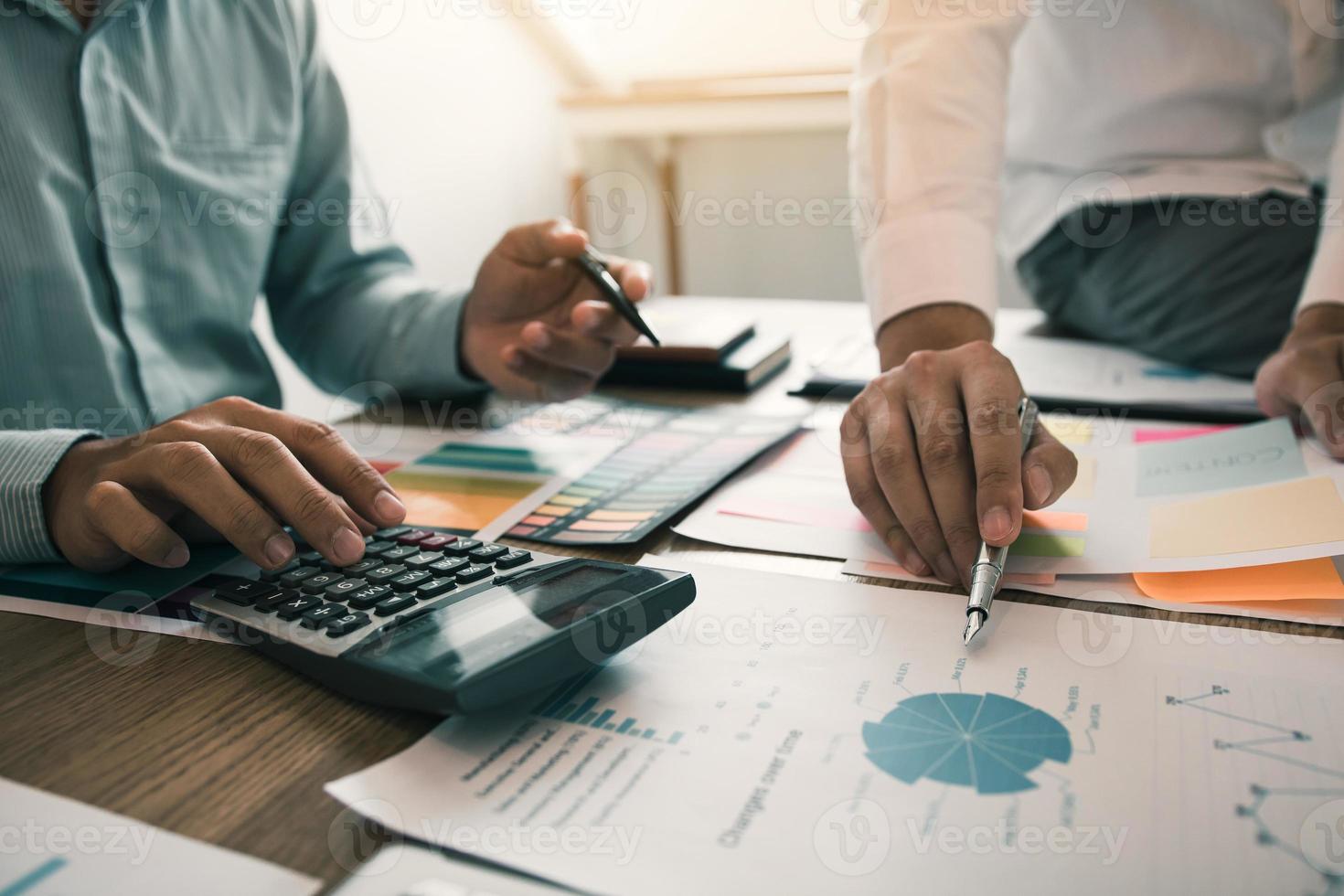 Two businessmen discussion analysis sharing calculations about the company budget and financial planning together on desk at the office room. photo