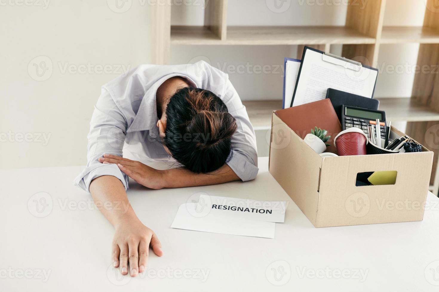 Woman employee feeling sad at his desk when he received the contract envelope for resigning from the company. photo