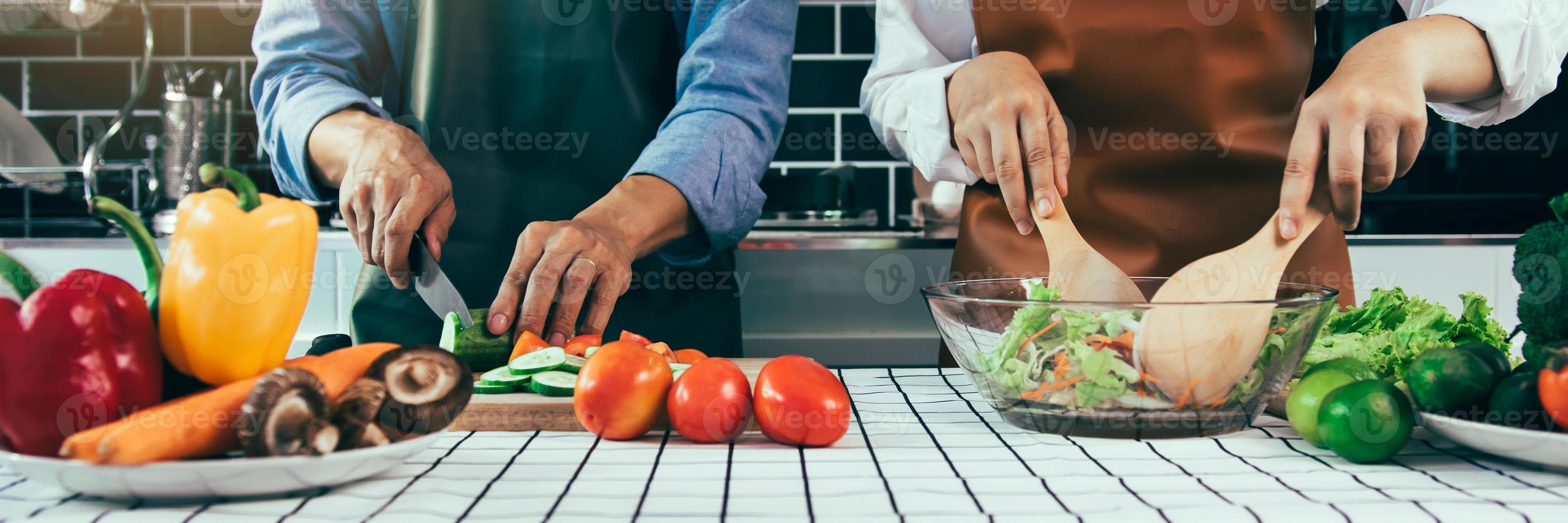 Two young asian couples are helping each other and enjoying cooking in the kitchen. photo