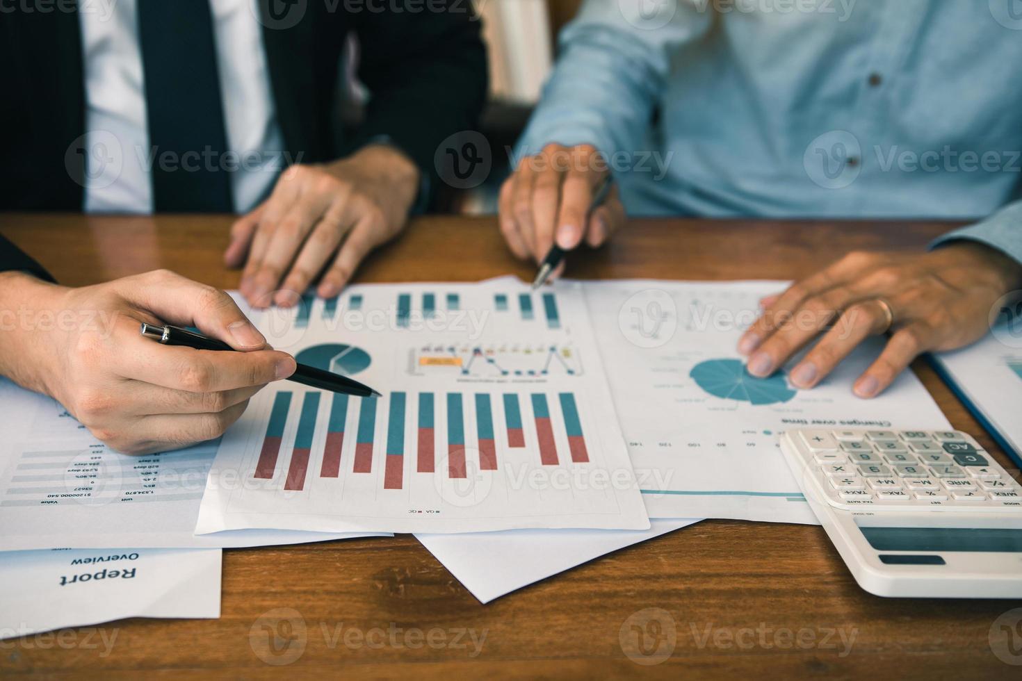 Two businessmen discussion analysis sharing calculations about the company budget and financial planning together on desk at the office room. photo