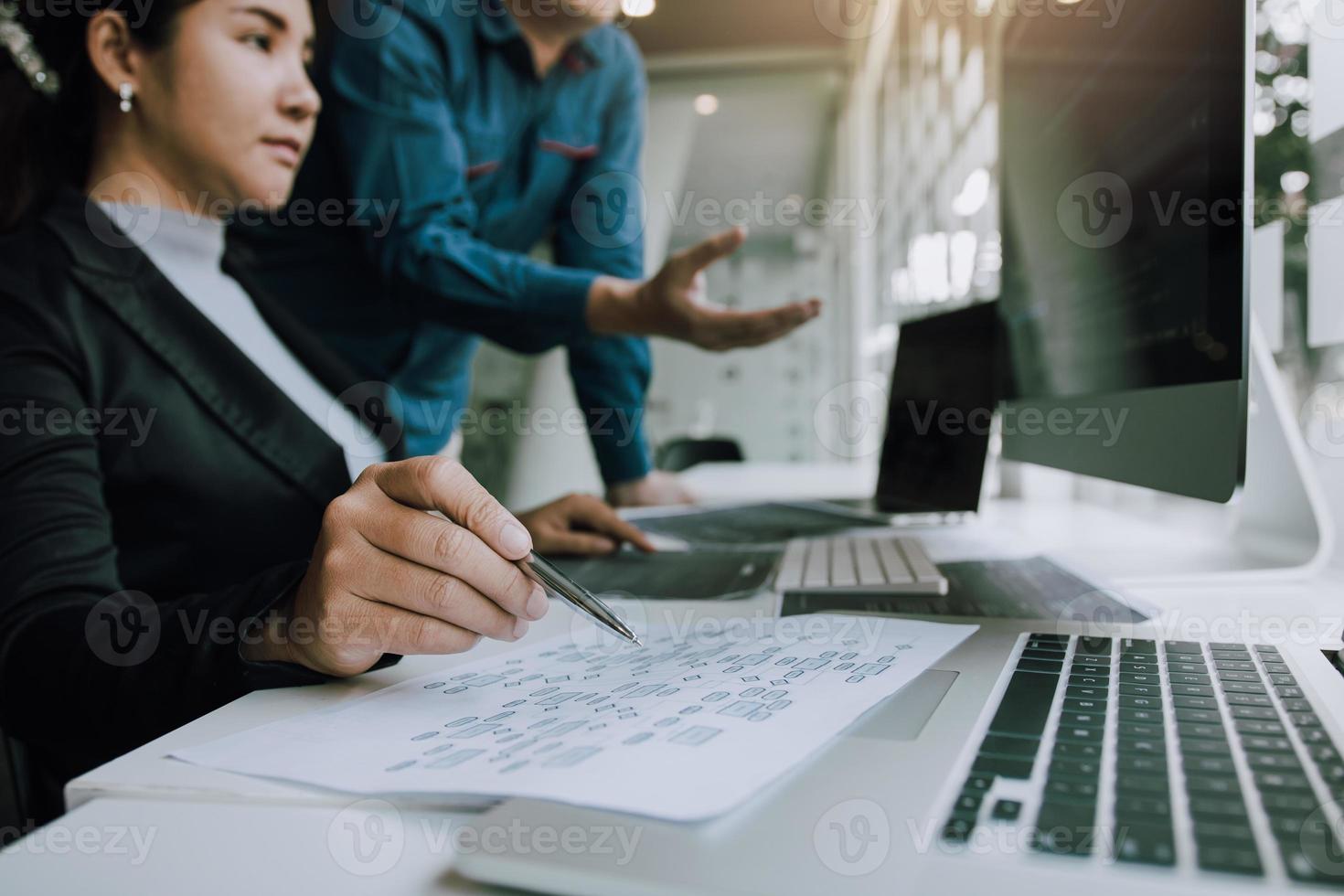 Two partnerships developing programming and coding technologies working on laptop and analyzing together. photo