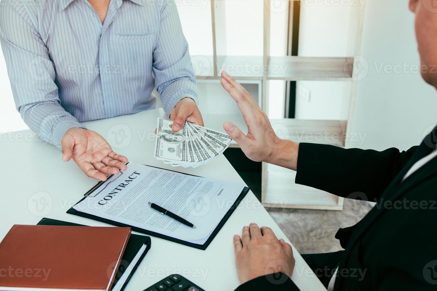Businessperson refusing bribe given money by partner with anti bribery corruption concept. photo