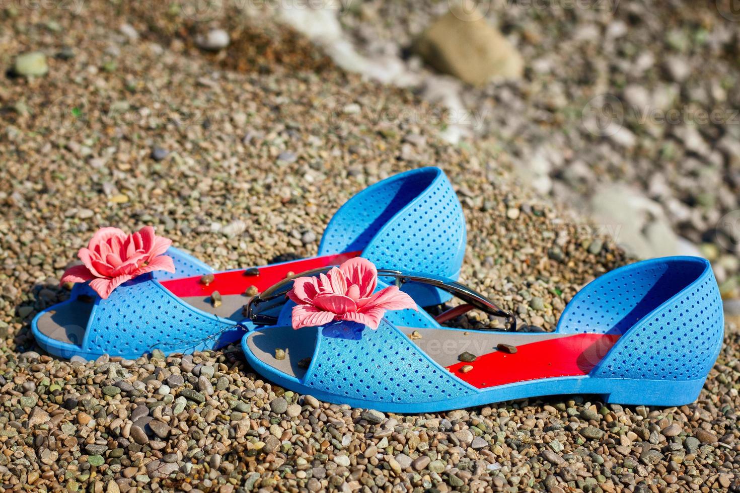 blue sandals on the beach by the sea, summer vacation concept photo