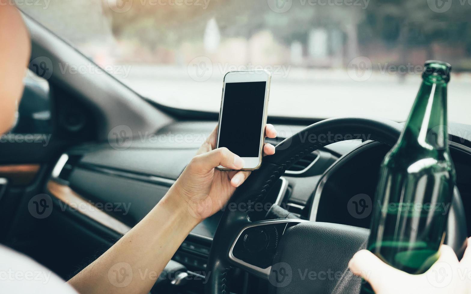 Asian men drink alcohol in the car and using mobile phones while driving. photo