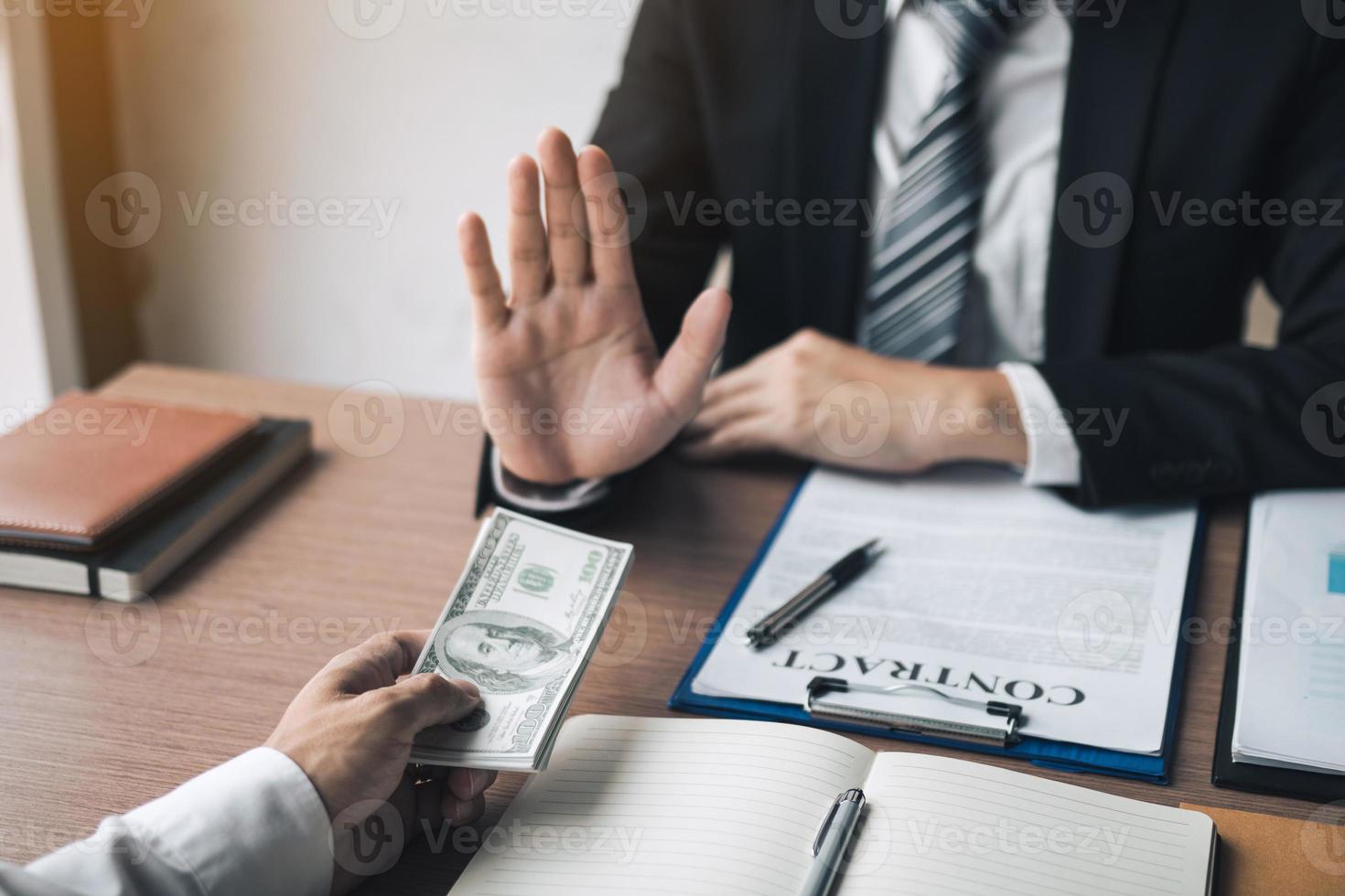 Business person refusing bribe given money by partner with anti bribery corruption concept. photo