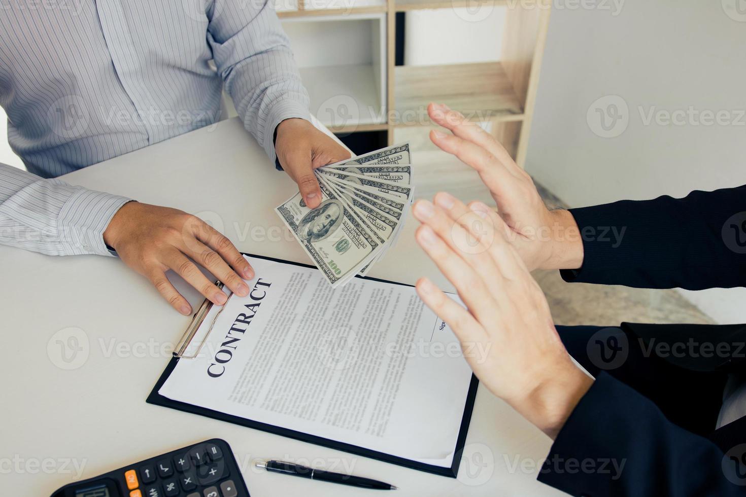 Businessperson refusing bribe given money by partner with anti bribery corruption concept. photo