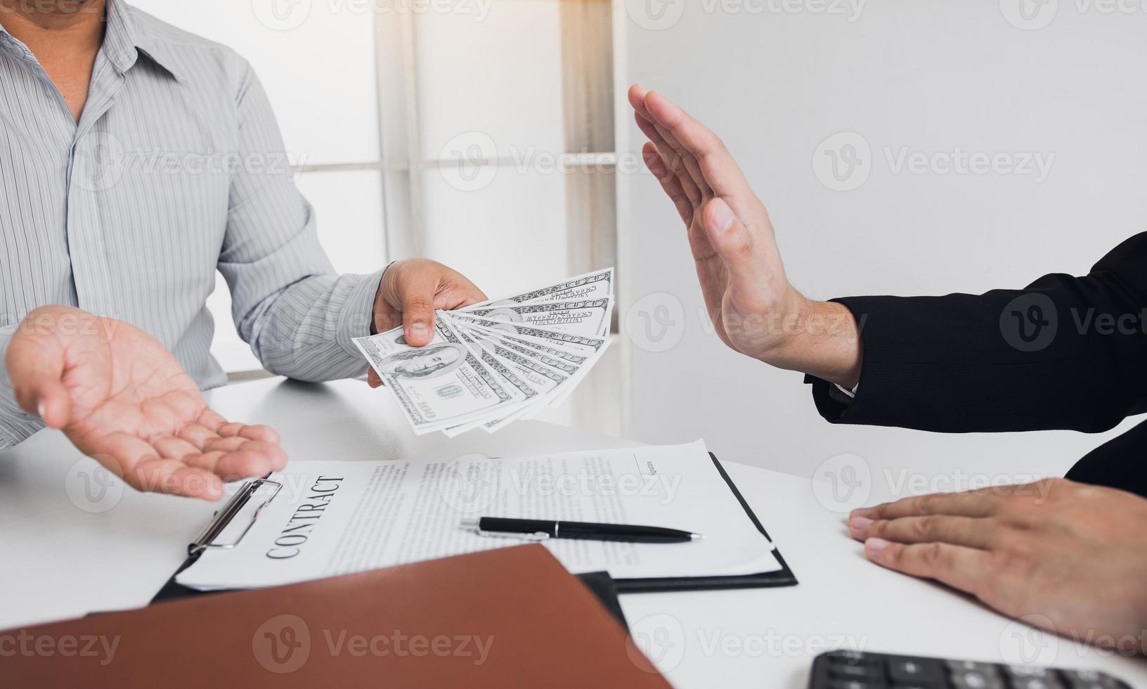 Businessperson refusing bribe given money by partner with anti bribery corruption concept. photo