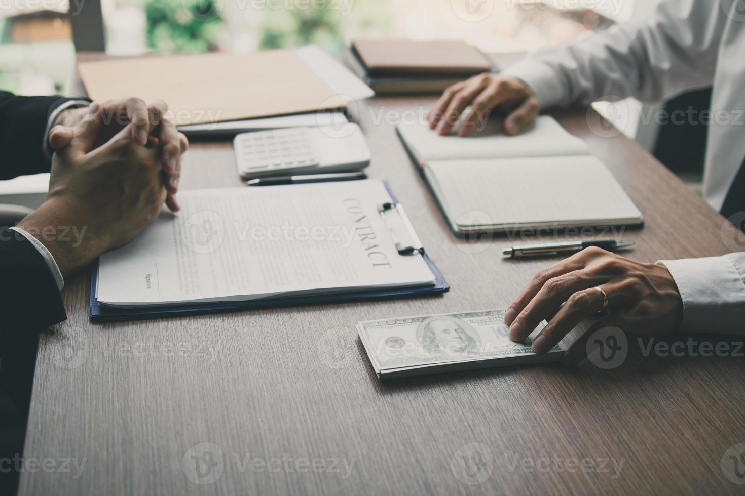 Partner has made a fraud in the contract of sale and being handed a cash and pen to the businessman signing the contract corruption bribery concept. photo
