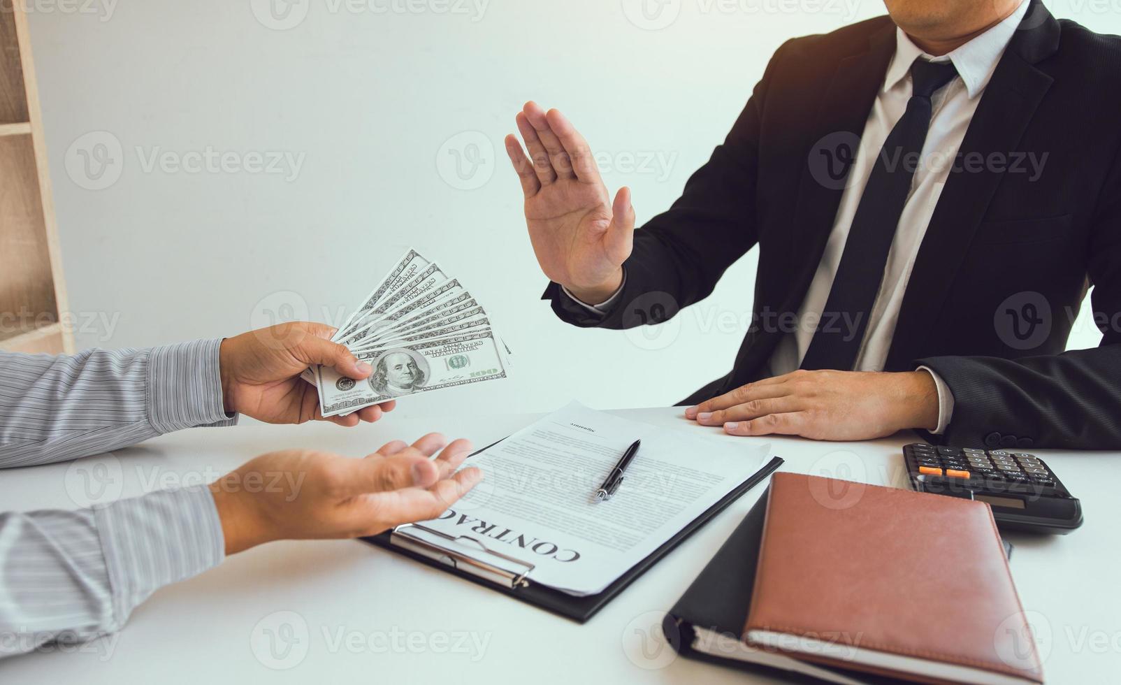 Business person refusing bribe given money by partner with anti bribery corruption concept. photo