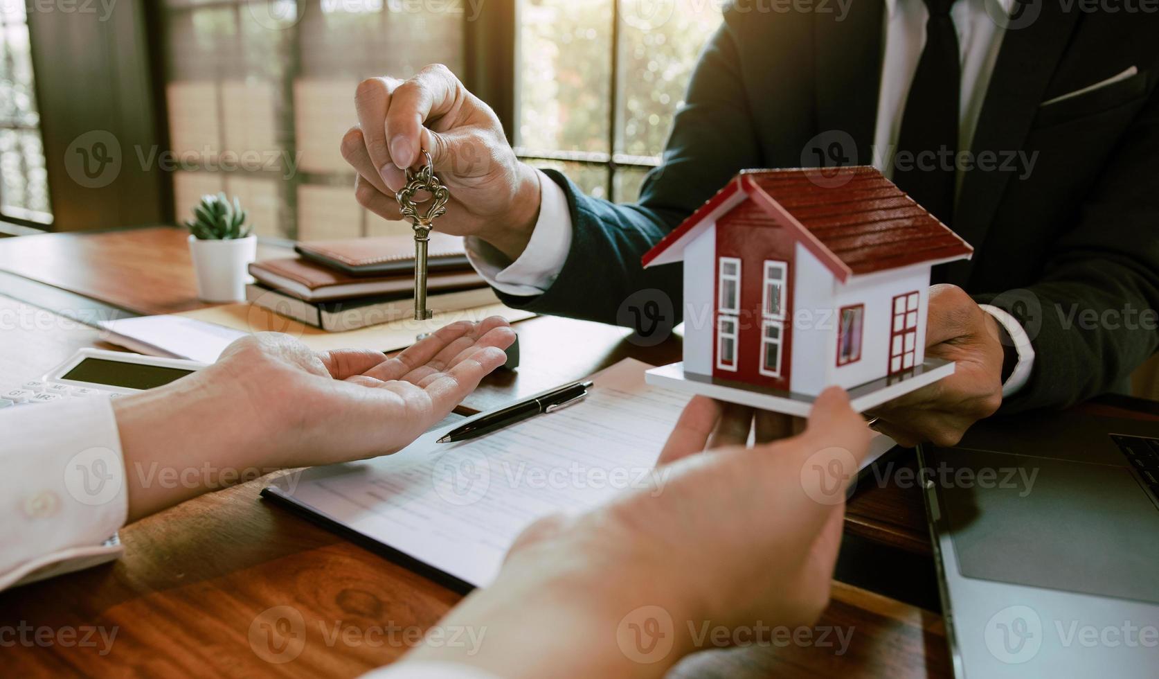 Home agents are handing out keys to home buyers who are signing contracts at the office. photo
