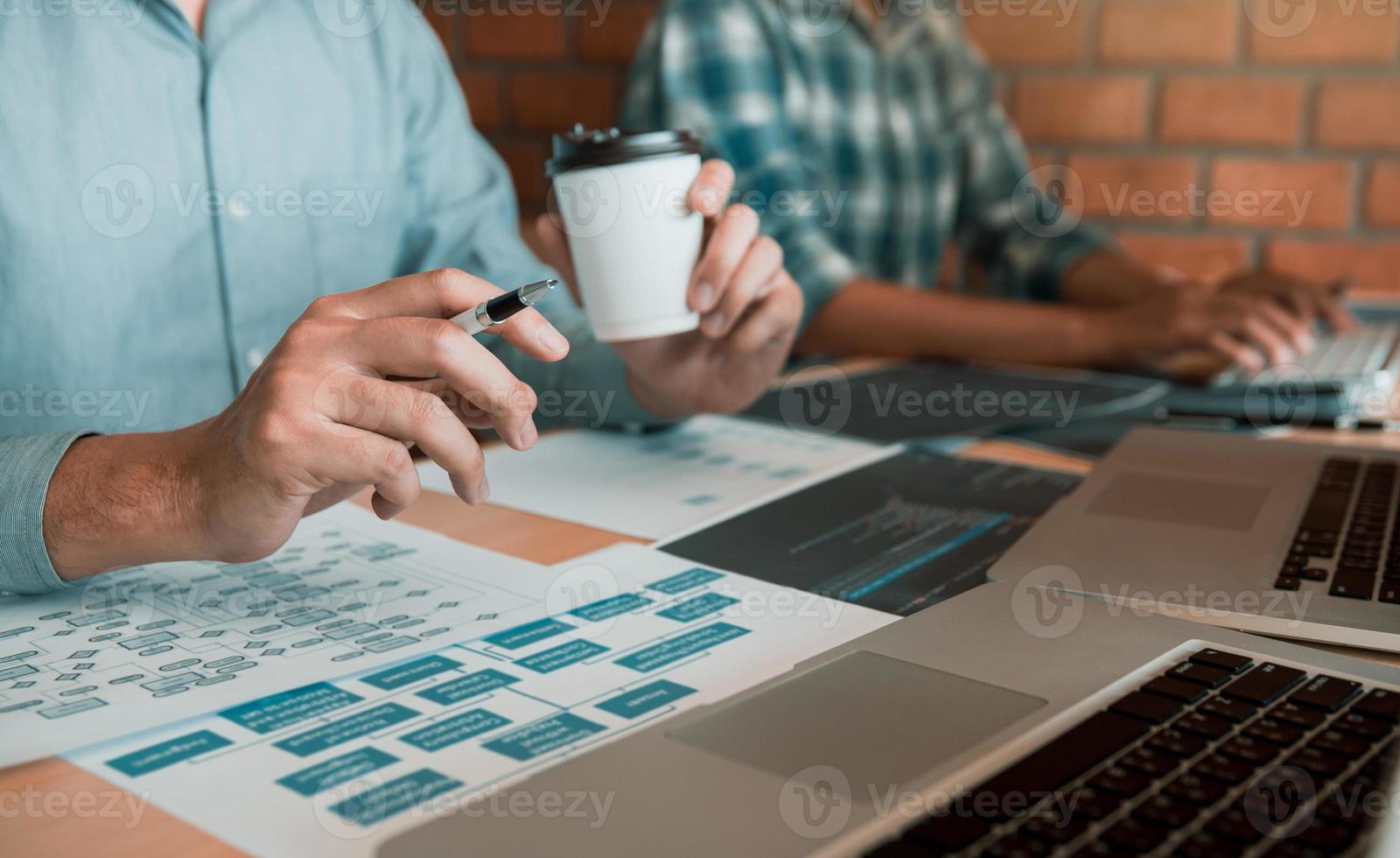 Working in the morning with businessmen are dipping coffee that works with software developers to analysis together the code written in the program on the computer. photo