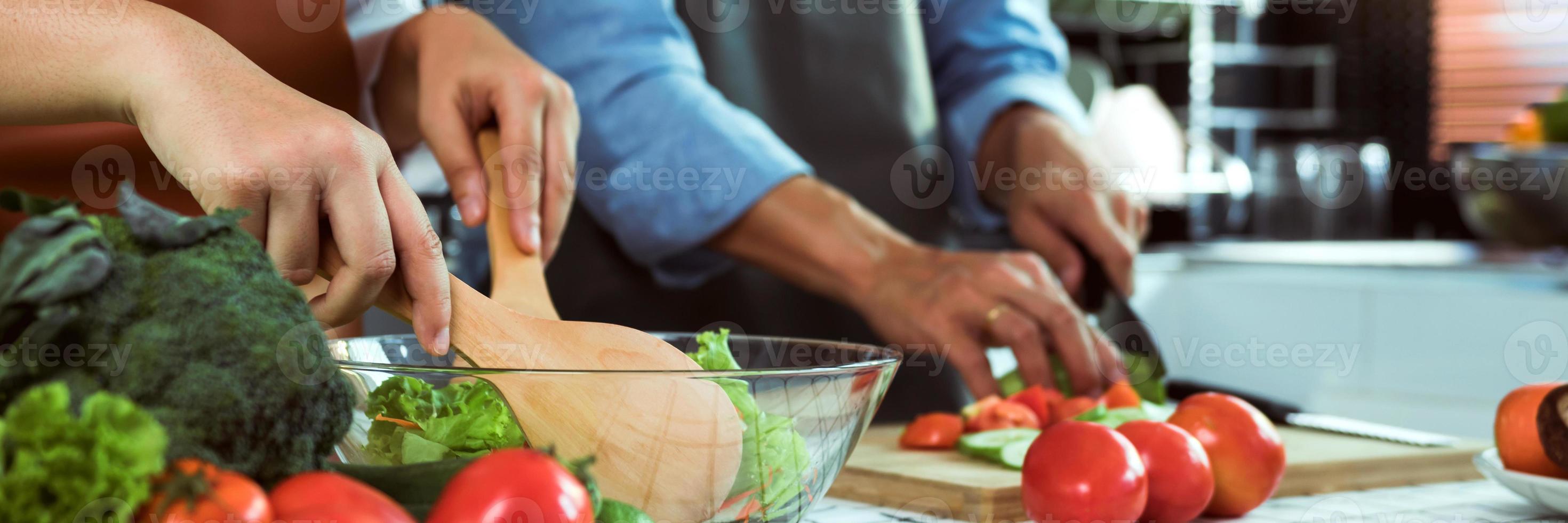 Young asian couple is preparing healthy food together and preparing for a happy lunch. photo