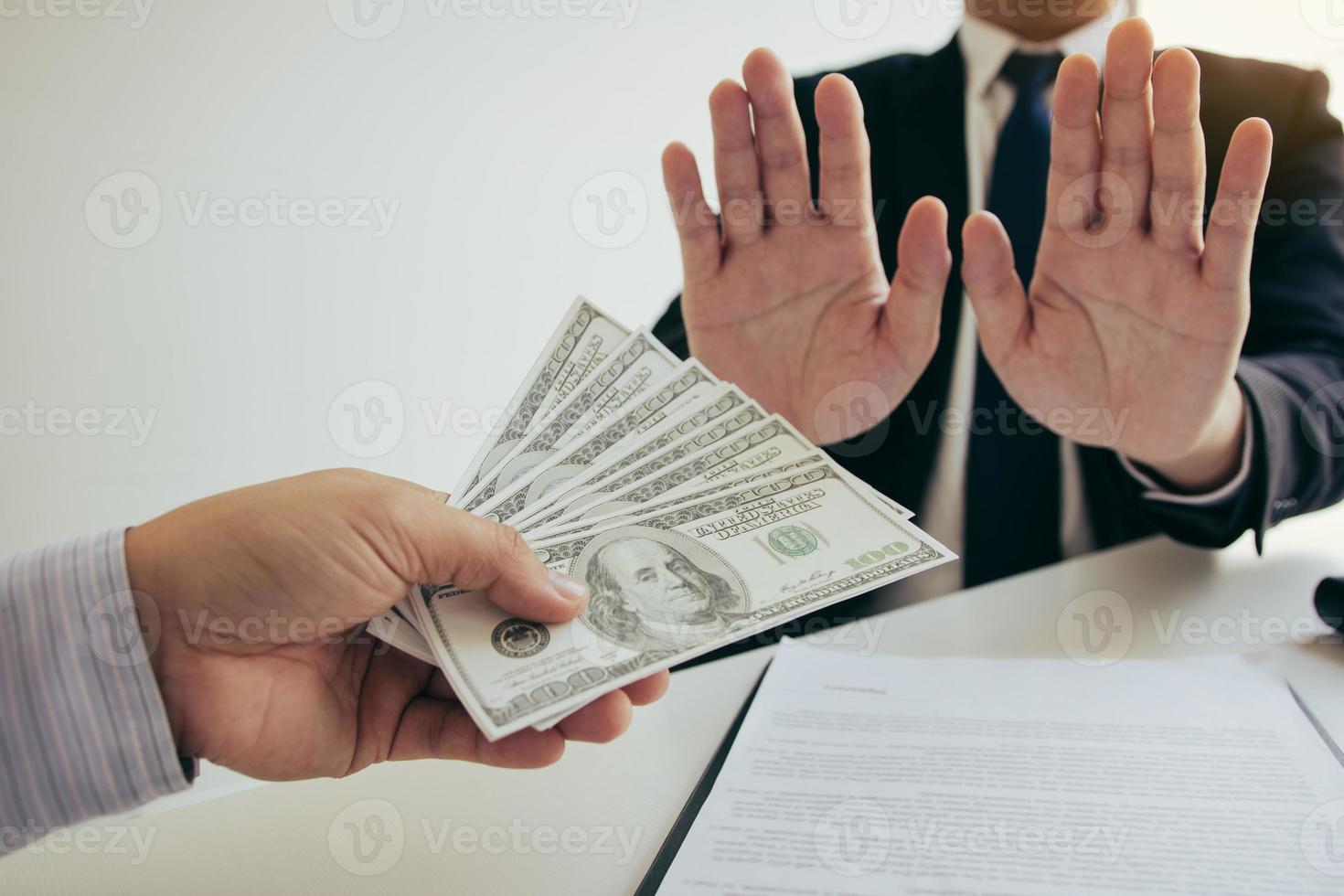 Business person refusing bribe given money by partner with anti bribery corruption concept. photo