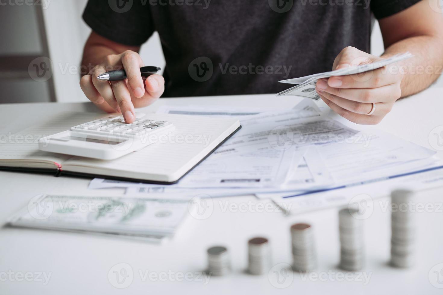 Man use calculators and documents that calculate expenses in the home office. photo