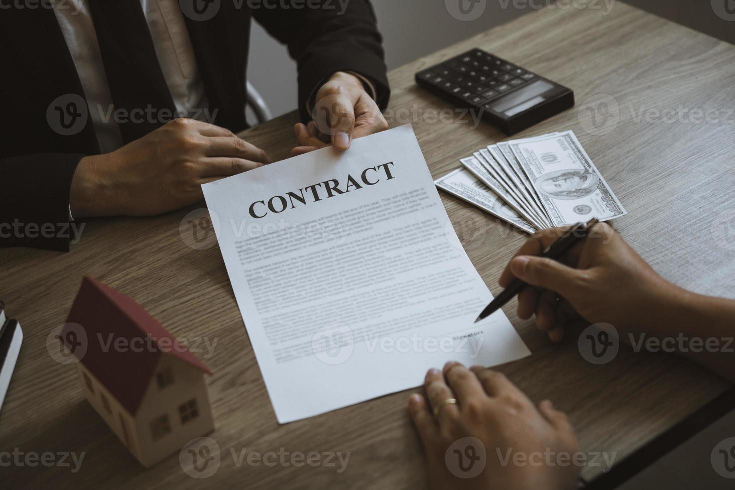 New home buyers are signing a home purchase contract at the agent's desk. photo