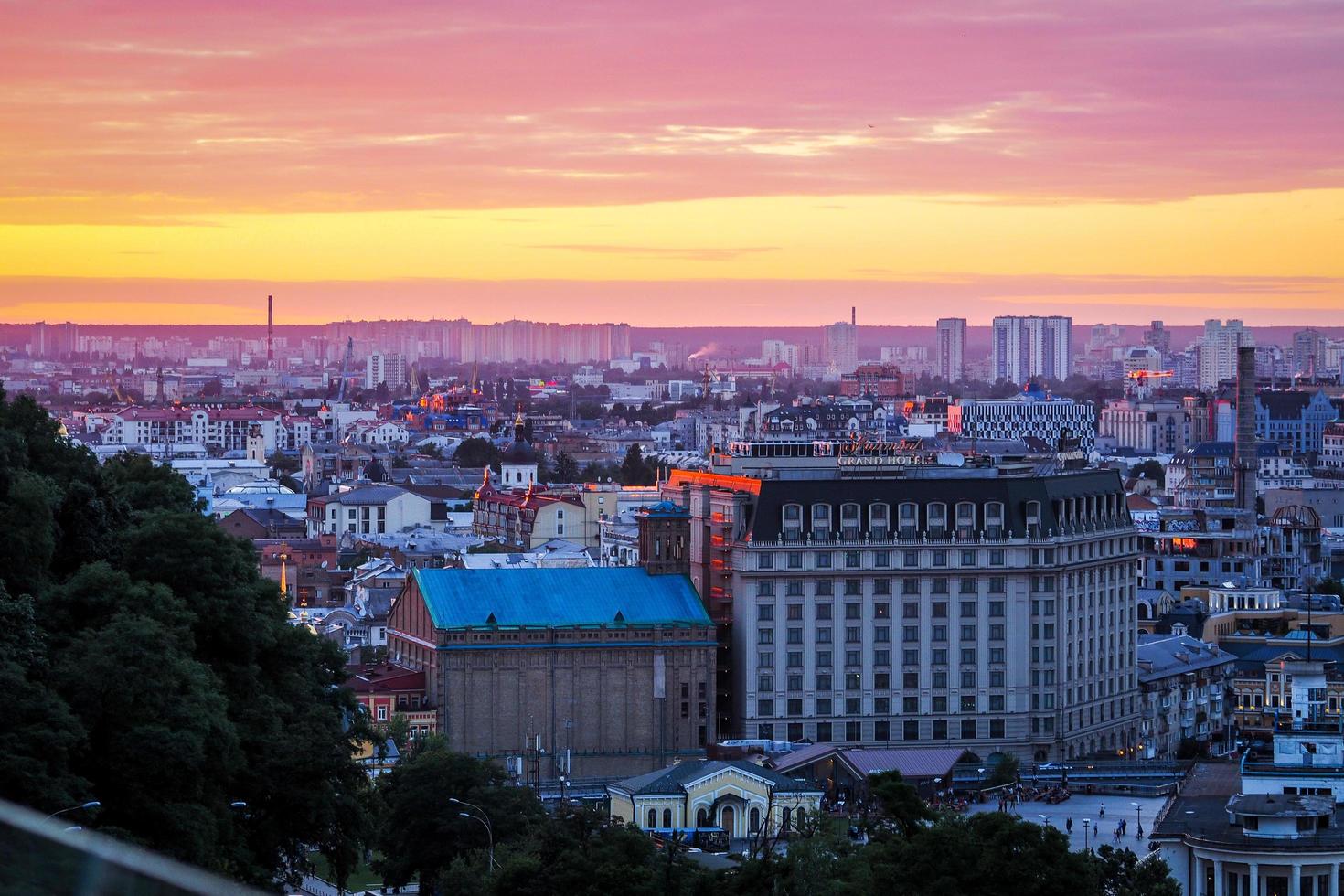 Kiev, Ukraine - July 4, 2019. Panorama of city Kiev, observation deck on the Dnipro, sunset sky in the background forms the flag of Ukraine. Defocused photo