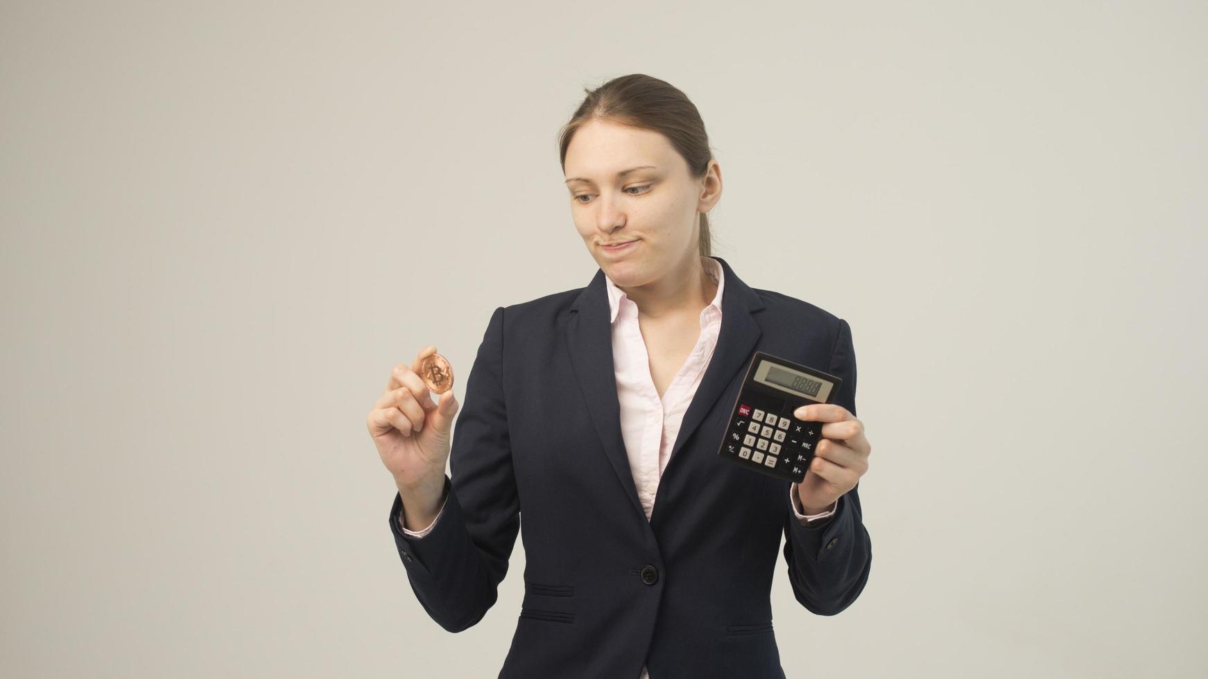 mujer sosteniendo una criptomoneda bitcoin física en la mano foto